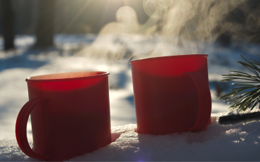 boissons chaude dans des tasse rouge posée dans la neige 