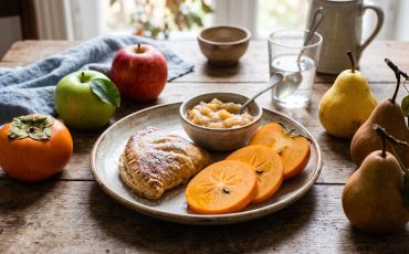 Pomme, poire, kaki : le goûter d'automne en montagne sur une table dans une assiette 