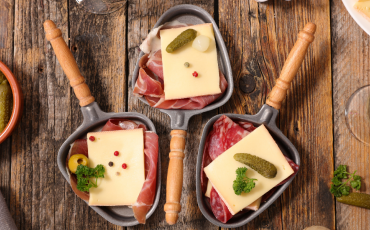 caclon de raclette avec fromage et charcuterie sur une table en bois prêt a déguster 