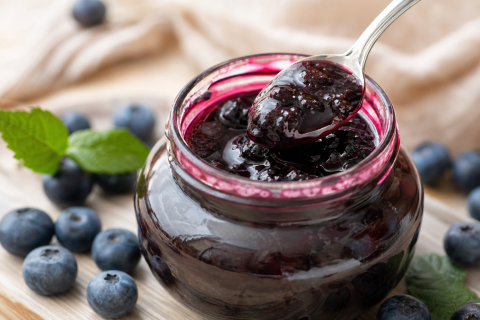 Pot de confiture de myrtille Terre de l'Alpe, gros plan avec une cuillère de confiture